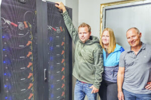 Kraftpakke: Eirin og Kai Inge Skjæveland saman med Kjetil Skjæveland frå Kverneland Energi (t.h.). Batteria har plass til 363 kilowattimar.