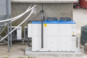 Kyllinghuset: Ny varmepumpe på 100 kilowatt er montert og skal i stor grad drivast med solkraft. Dei gamle einfasa pumpene i bakkant.