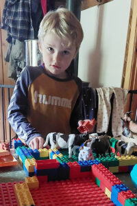 Innetid: Ola planlegg flôr, byggjer - og byggjer om. Det er robot, kalvebinge, lausdrift og beiteområde utanfor. Under bordet står traktorparken klar til transport av dyra.