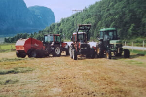 Rundballepressing: Stadig meir å hausta. Det første kulturbeitet i bakgrunnen.