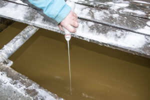 Kalk i lorten: Biokalk blir blanda i gjødsellageret ei til to gonger årleg. Ikkje med flaske som i demonstrasjonen her, men med tankbil. Eng og beite blir vedlikehaldskalka samstundes med husdyrgjødselspreiinga. Kanalomrøringa sviv dagleg og bidreg saman med kalken til at gjødselblandinga blir svært homogen.